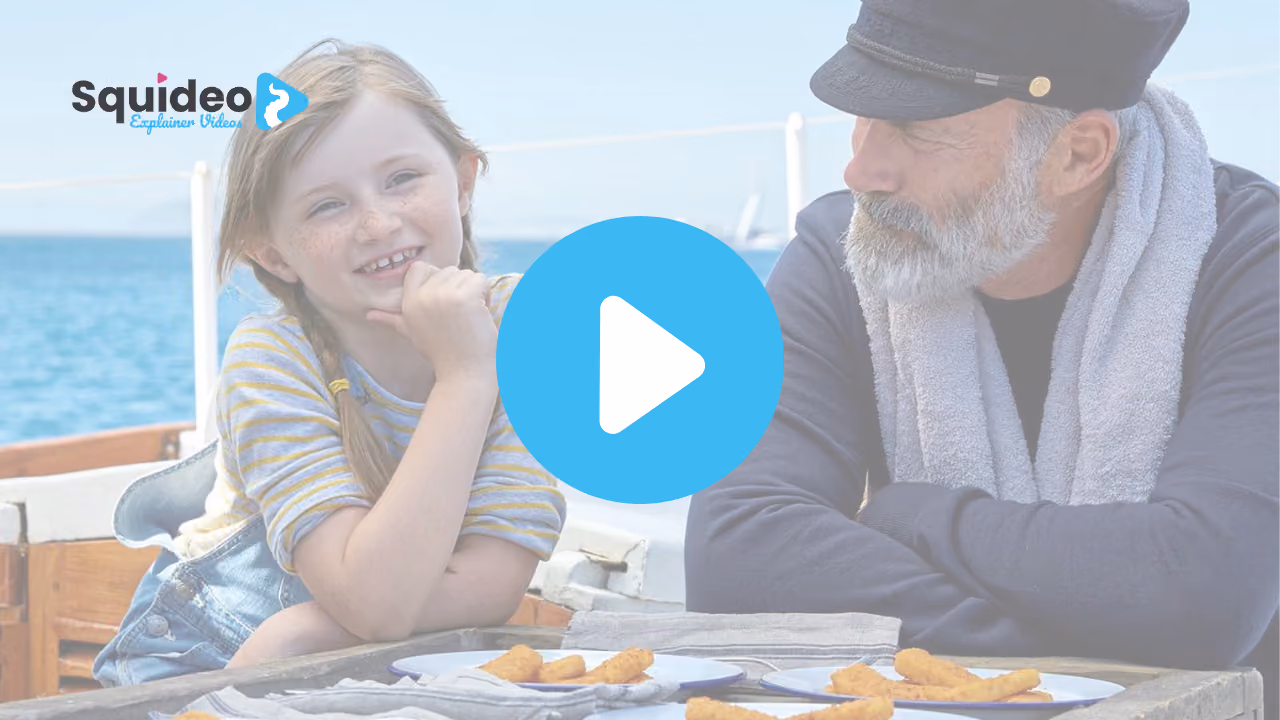 A girl and a bearded man in a captain's cap sitting at a table on a boat by the sea, plates of fish fingers in front of them