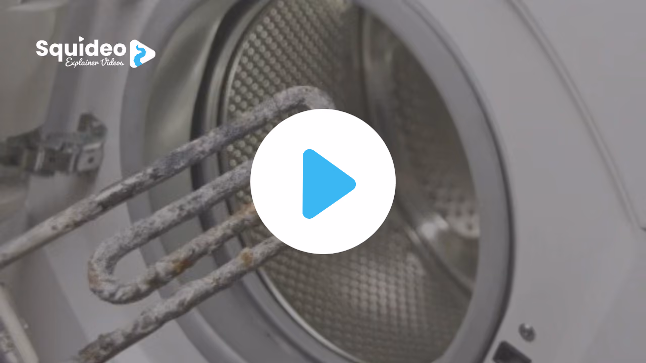 A washing machine heating element caked in grey limescale, held in front of the open drum
