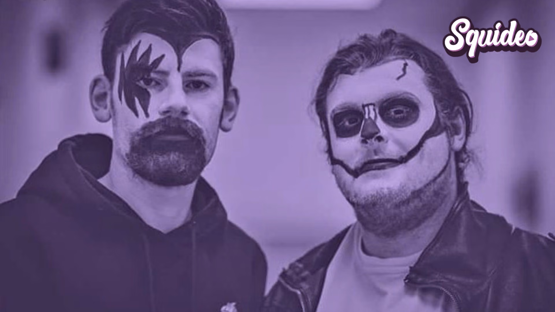 Two men in Halloween face paint, tinted purple, one with a black spiked design across one eye and the other made up as a skull, under the Squideo logo