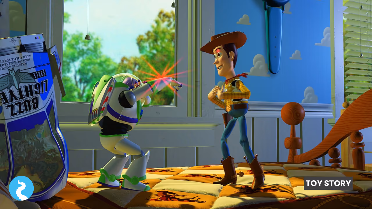 A still from Toy Story: Buzz Lightyear firing his red laser beam across the bed at Woody, who is looking down at his own chest, the Buzz Lightyear packaging propped against the window behind