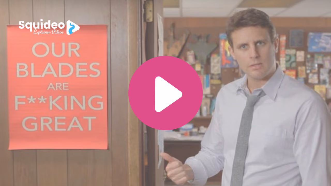 A man in a shirt and tie in a stockroom, gesturing back over his shoulder at a pink poster reading 'Our blades are f**king great'