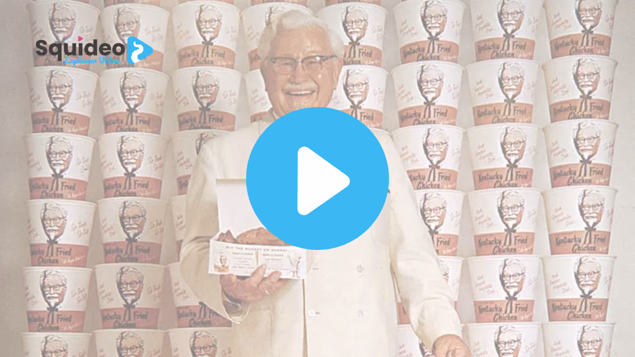 Colonel Harland Sanders in his white suit and string tie, holding a leaflet in front of a wall stacked with Kentucky Fried Chicken buckets