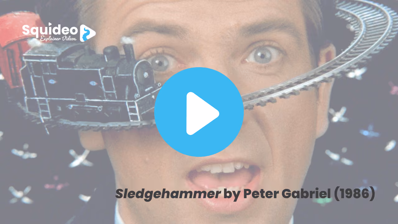 A still from Sledgehammer by Peter Gabriel, 1986: stop-motion, a model steam train running on a track around a man's wide-eyed face