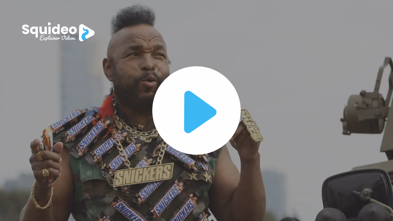 Mr T in a camouflage vest hung with Snickers bars and gold chains, holding one up beside an army jeep